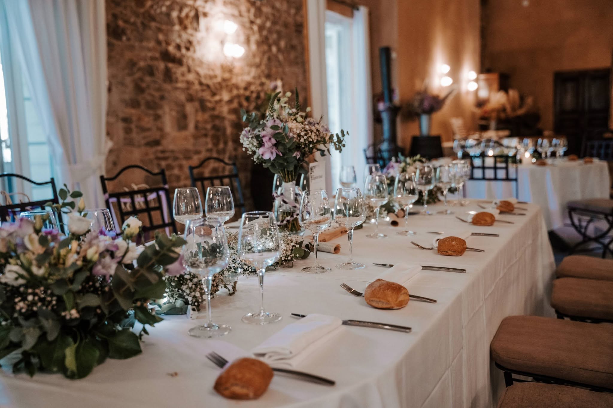 Décoration florale d’une réception, avec feuillages, fleurs blanches et mauves